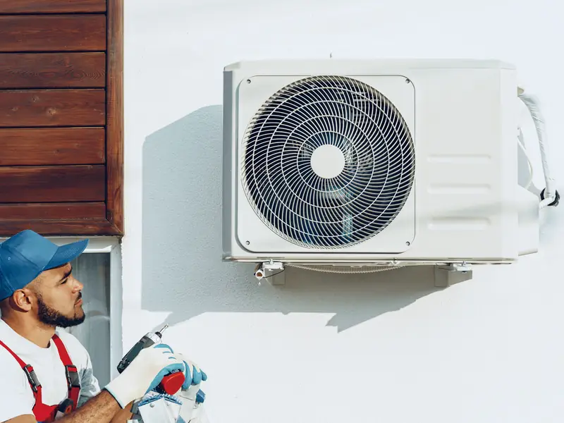 installation climatisation cote d azur 4 m Technicien Dosantos à côté d'un groupe extérieur fixé au mur